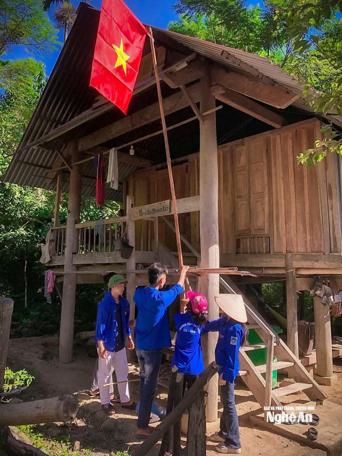 Đoàn viên thanh niên xã Hùng Chân hỗ trợ các hộ gia đình treo cờ tổ quốc trước ngày Quốc khánh. Ảnh: Kế Kiên