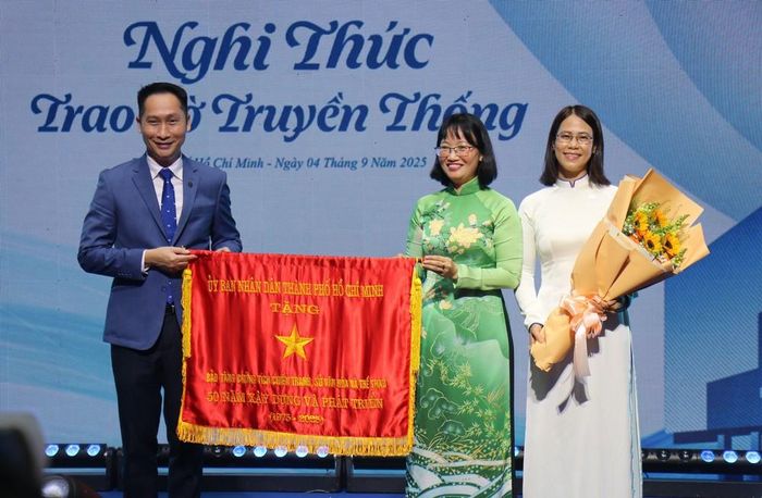 Bà Trần Thị Diệu Thúy (giữa), Phó Chủ tịch UBND Thành phố Hồ Chí Minh, trao cờ truyền thống của UBND Thành phố cho Bảo tàng Chứng tích Chiến tranh. Ảnh: Thu Hương - TTXVN