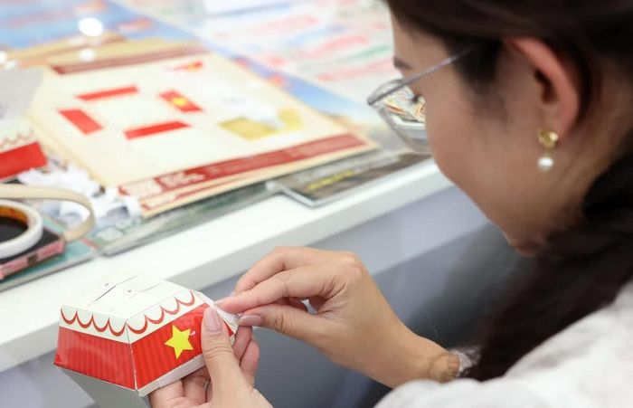 Các ấn phẩm, phụ trang của Thông tấn xã Việt Nam đến tay người dân tại triển lãm. Ảnh: Quốc Khánh - TTXVN