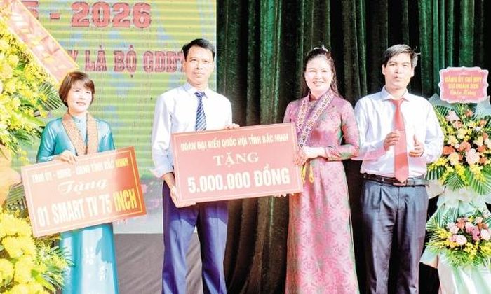Phó Trưởng Đoàn Đại biểu Quốc hội tỉnh Trần Thị Vân tặng quà Trường Dân tộc nội trú trung học cơ sở và trung học phổ thông Nguyễn Tất Thành, xã Kiên Lao trong ngày khai giảng.