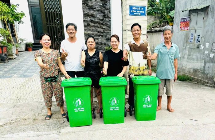 Ông Trần Quang Huy, Trưởng ban Công tác mặt trận thôn An Hiền (thứ hai bên phải)vận động nhân dân sử dụng thùng rác thông minh và phân loại rác thải tại nguồn. Ảnh: Quang Huy