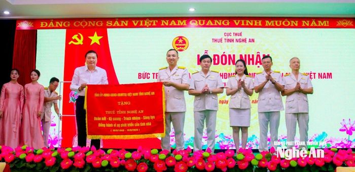 Chủ tịch UBND tỉnh Lê Hồng Vinh trao bức trướng của Tỉnh ủy - HĐND - UBND - Ủy ban MTTQ Việt Nam tỉnh tặng ngành Thuế Nghệ An. Ảnh: Thành Duy