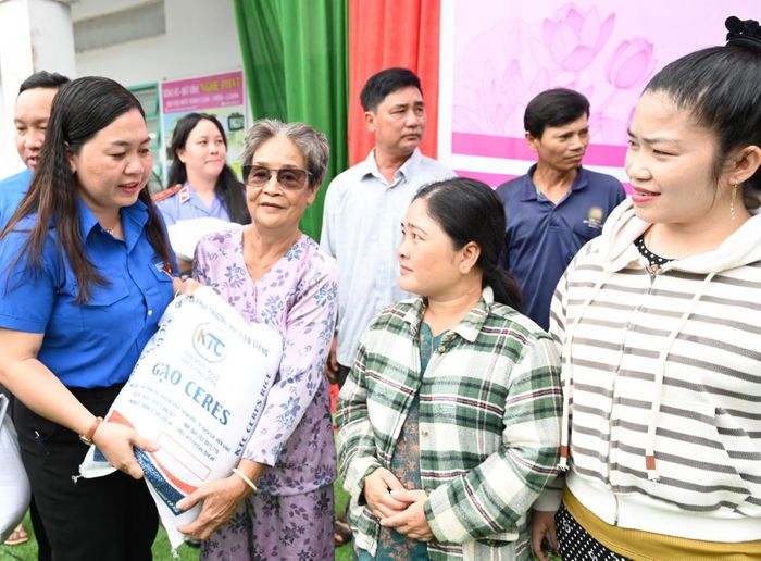 Chị Thị Phương Hồng tặng quà cho gia đình người có công, gia đình có hoàn cảnh khó khăn xã Vĩnh Điều. Ảnh: HUỲNH ANH