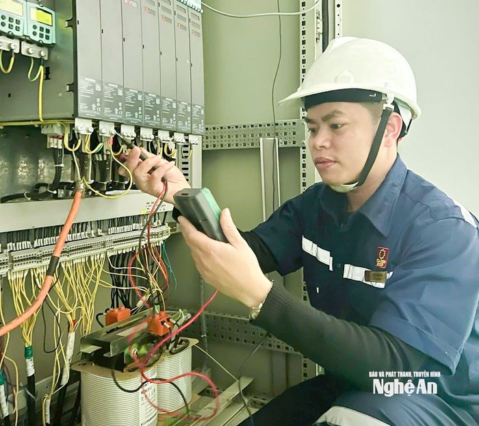 Anh Vũ Xuân Hiệu kiểm tra thiết bị điện phục vụ dây chuyền sản xuất. Ảnh: Mai Hoa