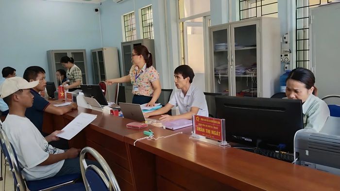  Anh Hoàng Mạnh Toản (giữa ảnh) tiếp nhận và hướng dẫn thủ tục hành chính cho người dân xã Trịnh Tường. 