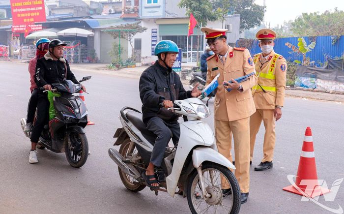 Cảnh sát giao thông Công an tỉnh phát tờ rơi tuyên truyền về an toàn giao thông cho người dân.