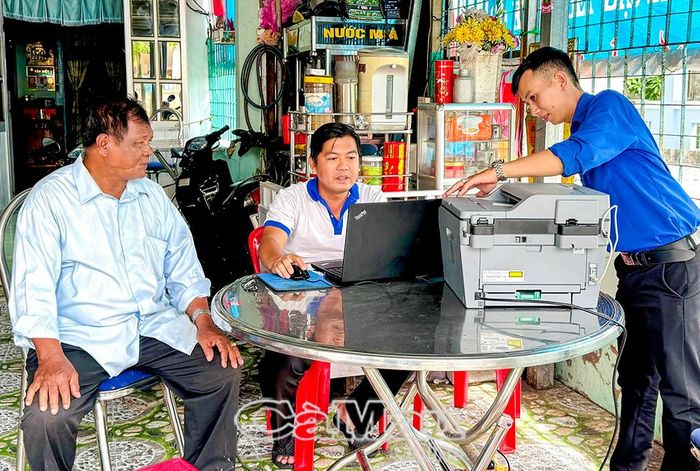 Ông Sơn Liên được cán bộ hướng dẫn thực hiện thủ tục hưởng trợ cấp hưu trí xã hội.