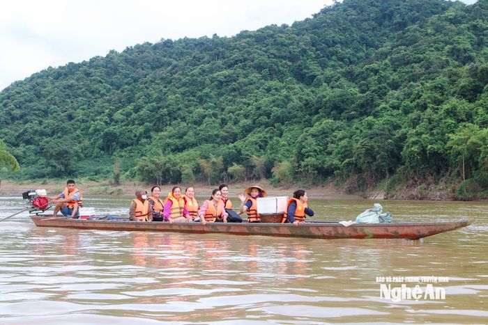 Ngày cuối tuần, cán bộ, công chức Trung tâm Phục vụ hành chính công xã Tương Dương đã mang theo thiết bị, vượt sông vào tận các bản để tiếp nhận, hướng dẫn và trực tiếp giải quyết thủ tục cho người dân đang bị chia cắt. Ảnh: Đình Tuân