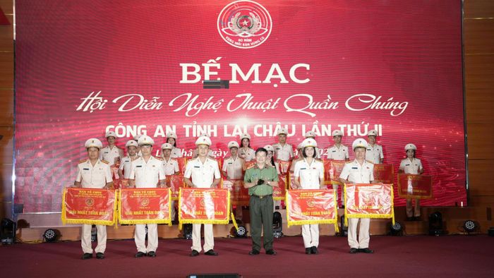 Đại tá Sùng A Súa - Phó Giám đốc Công an tỉnh, Trưởng Ban Tổ chức Hội diễn trao cờ cho 5 đội giành giải nhất toàn đoàn.