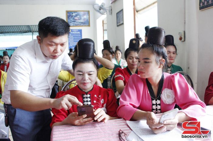 Cán bộ phường Chiềng Cơi hướng dẫn hội viên phụ nữ cài đặt và sử dụng ứng dụng số trên điện thoại.