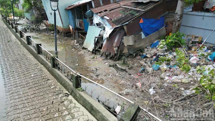 Tại chân cầu Kênh Thanh Đa, từng mảng đất dưới bờ kênh đổ sạt, hình thành những vết sụt lún sâu hoắm.