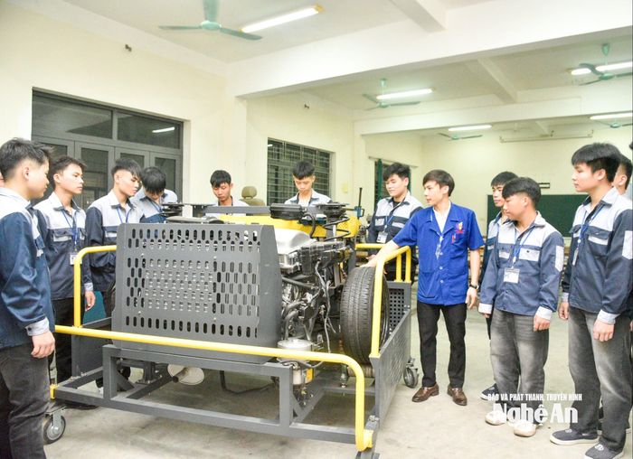 Thầy Nguyễn Quốc Cường hướng dẫn học sinh tìm hiểu cấu trúc động cơ hybrid. Ảnh: Minh Quân