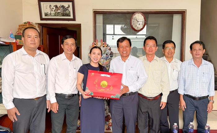 Phó Giám đốc PC An Giang Đổng Lưu Nghiêm (giữa) tặng quà Công ty trách nhiệm hữu hạn Thương mại xuất nhập khẩu Đạt Nghĩa (ấp Bình Quới, xã Hội An, tỉnh An Giang).