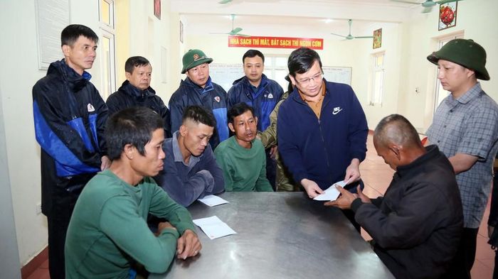Ông Nguyễn Văn Thái, Bí thư Đảng ủy xã Bắc Trạch (Quảng Trị), tặng quà động viên 4 thuyền viên may mắn thoát nạn trong vụ 2 tàu cá bị chìm. Ảnh: Tá Chuyên – TTXVN