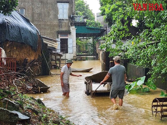 Người dân vận chuyển thuyền mộc đến để di chuyển tài sản khỏi vùng ngập lụt
