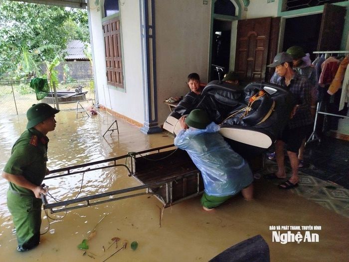 Công an xã Thành Bình Thọ giúp dân di dời tài sản, tránh lũ. Ảnh: Văn Trường