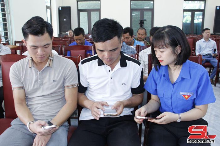 Đoàn viên thanh niên phường Chiềng Cơi hướng dẫn tổ công nghệ số cộng đồng truy cập các ứng dụng số. 