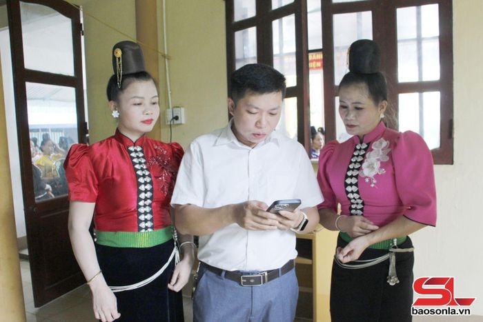 Cán bộ phường Chiềng Cơi hướng dẫn hội viên phụ nữ bản Chậu Cọ cài đặt và sử dụng APP "Cư dân số". 
