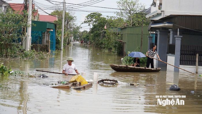 Người dân nỗ lực xử lý rác thải trong điều kiện nước lũ dâng cao. Ảnh: Thanh Quỳnh