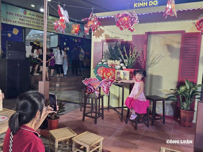 Khu vực photobooth tái hiện hình ảnh ngôi nhà truyền thống, bên cạnh đèn cá chép và hộp bánh trung thu. Ảnh: Hoài Phương