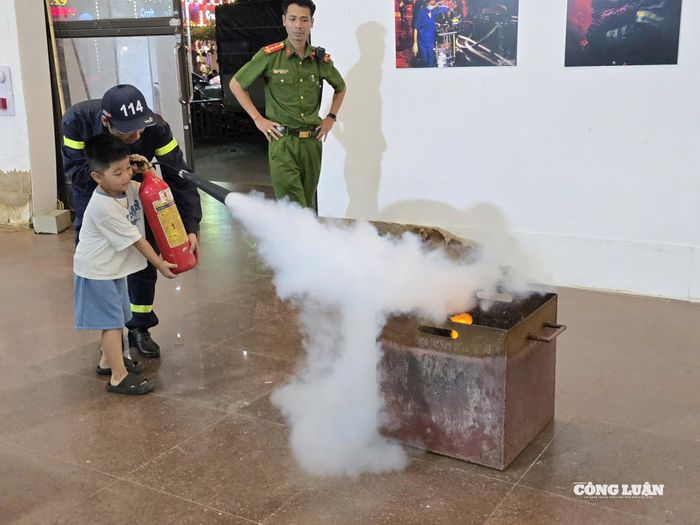 Các em được hướng dẫn sử dụng bình chữa cháy trong hoạt động chủ đề "Em làm lính cứu hỏa". Ảnh: Hoài Phương