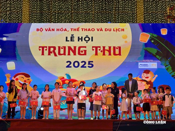 Đại diện nhà tài trợ Công ty Mondelez Kinh Đô trao quà cho các em thiếu nhi. Ảnh: Hoài Phương