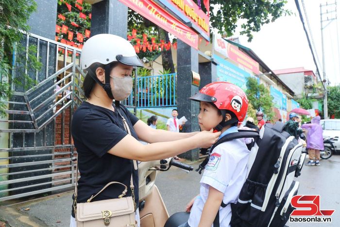 Đa số phụ huynh học sinh đều chấp hành nghiêm việc đội mũ bảo hiểm cho con khi đi học.