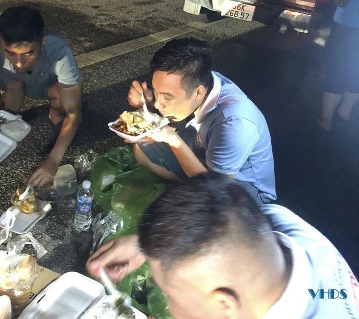 Thành viên Đội xe 0 đồng tranh thủ ăn vội suất cơm để tiếp tục hỗ trợ bà con vùng lũ.