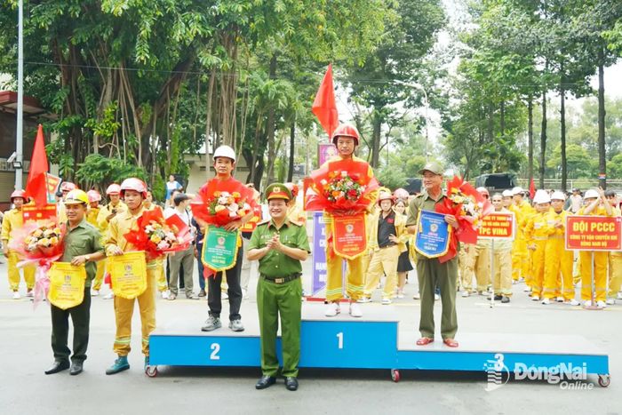 Đại tá Trần Anh Sơn, Phó Giám đốc Công an tỉnh Đồng Nai trao giải cho các đội đạt thành tích cao ở nội dung thi “Đội hình tổng hợp 300m chữa cháy, cứu người, cứu tài sản”. Ảnh: Lê Duy