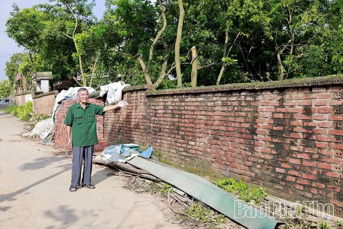 Theo hướng chỉ tay là tường rào của một gia đình có diện tích đất mặt tiền lớn, giá trị rất cao đã tự nguyện hiến hàng chục mét vuông đất để mở rộng đường