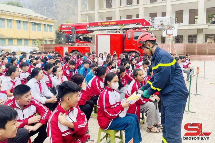 Phát tờ rơi cho học sinh Trường TH&amp;THCS Chiềng Xôm về các kỹ năng thoát nạn an toàn ra khỏi đám cháy. 