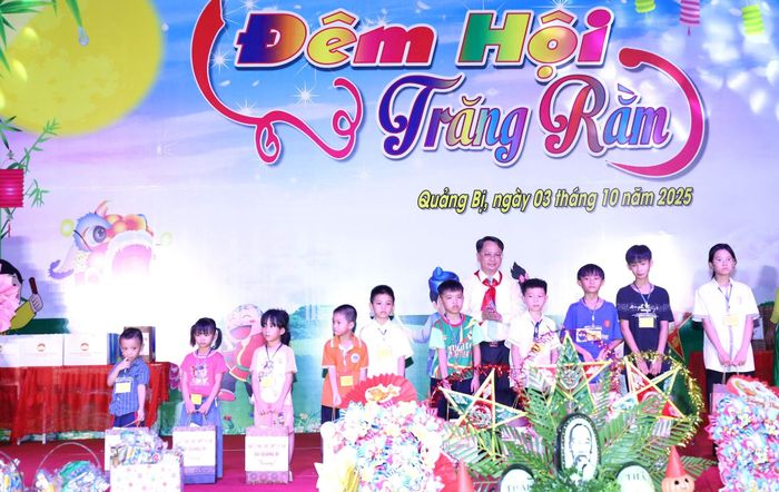 Chủ tịch UBND xã Quảng Bị Bùi Mạnh Thắng trao quà của xã cho thiếu nhi trên địa bàn. Ảnh: Kim Nhuệ