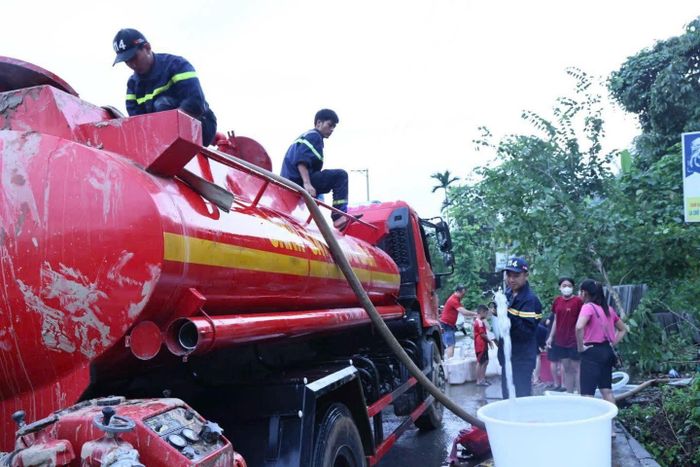 Cảnh sát PCCC và CNCH Công an tỉnh Tuyên Quang tiếp nước sạch cho người dân phường Hà Giang 1 vừa vượt qua lũ lụt. Ảnh: PC07