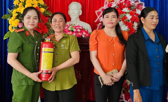 Cảnh sát PCCC và CNCH Công an tỉnh Cà Mau tặng bình chữa cháy cho mô hình Tổ phụ nữ phòng, chống tội phạm. Ảnh: PC07