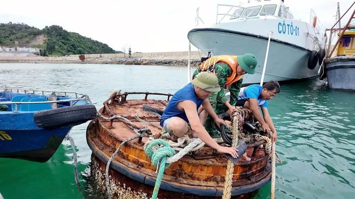 Cán bộ, chiến sĩ Đồn biên phòng Trà Cổ chằng buộc tàu thuyền, cùng nhân dân chống bão. Ảnh: TTXVN phát
