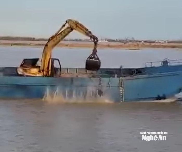 Chiếc máy xúc ở trên khoang tàu liên tục xúc rác đổ xuống sông gây bức xúc. Ảnh: cắt từ clip