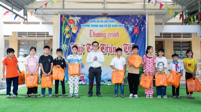Ông Lê Thanh Khiết - Trưởng Ban Xây dựng Đảng, Đảng ủy xã An Lạc Thôn, trao tặng quà của Đoàn Thanh niên PVPGB cho các em học sinh.
