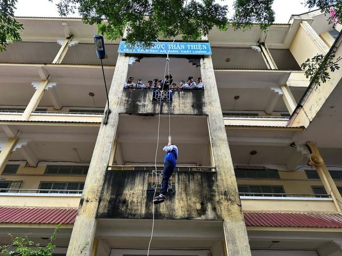  Học sinh trải nghiệm đội hình thoát nạn bằng dây hạ chậm. Ảnh: Văn Ngọc 