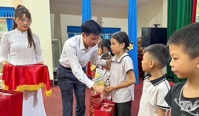 Đồng chí Trưởng Ban Tổ chức Tỉnh ủy tặng quà cho các học sinh có hoàn cảnh khó khăn trên địa bàn xã Nghinh Tường.
