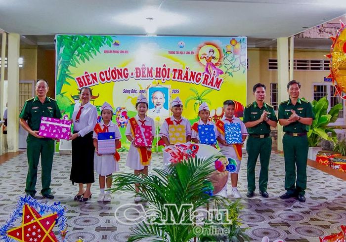 Thượng tá Nguyễn Chí Nguyện, Phó Chủ nhiệm Chính trị BĐBP Cà Mau (thứ 2, bên phải qua) và đại diện Đồn Biên phòng Sông Đốc, tặng quà Trung thu cho các em học sinh tại Tiểu học Sông Đốc 1.
