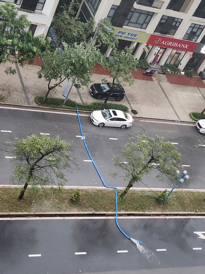  Để xử lý ngập úng bên trong khu đô thị, Ban quản lý Starlake hút nước mưa và xả ra tuyến đường 40 m phía trước. Ảnh: CDCC. 