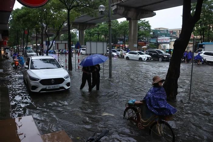 Đường Cầu Diễn ngập sâu, ảnh hưởng lớn đến việc di chuyển của người dân sáng 7/10. Ảnh: Văn Điệp - TTXVN
