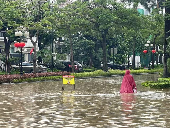 Nước ngập sâu khiến người dân di chuyển khó khăn trong khu đô thị Ciputra, phường Phú Thượng, Hà Nội. Ảnh: Hùng Mạnh - TTXVN