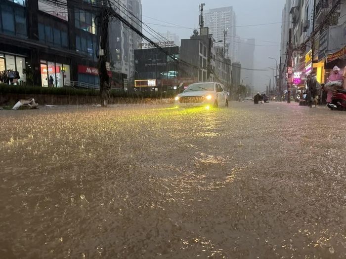 Tại phố Nguyễn Tuân (Hà Nội), nước đã dâng cao khoảng 40cm gây khó khăn cho việc đi lại của phương tiện tham gia giao thông. Ảnh: Quốc Lũy - TTXVN