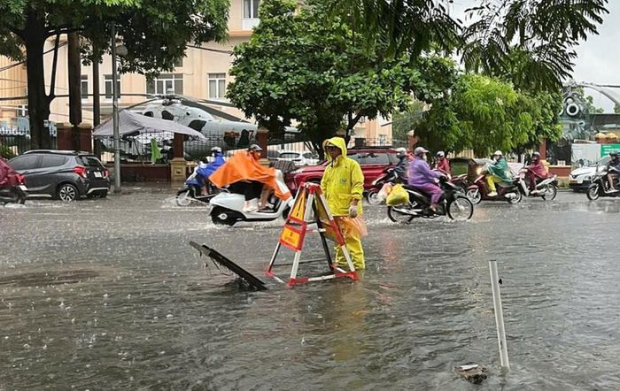 Công nhân ứng trực tiêu thoát nước trên đường Lê Trọng Tấn. Ảnh: Nguyễn Thắng - TTXVN