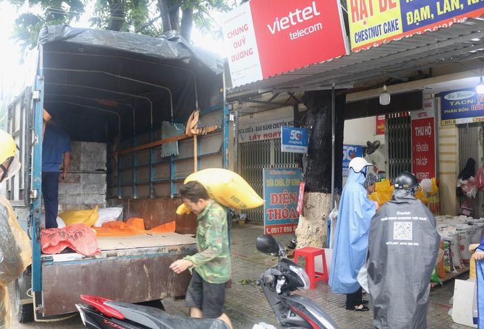 Người dân khẩn trương di dời tài sản ra khỏi vùng nguy cơ ngập lụt. Ảnh: Chu Hiệu-TTXVN.