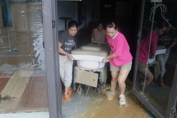 Người dân khẩn trương di dời tài sản ra khỏi vùng nguy cơ ngập lụt. Ảnh: Chu Hiệu-TTXVN.