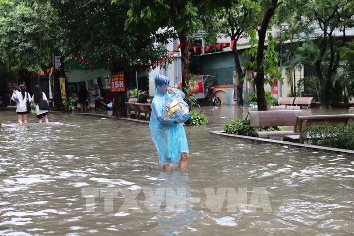 Mưa ngập khiến việc di chuyển, sinh hoạt của người dân gặp nhiều khó khăn. Ảnh: Vũ Quang – TTXVN
