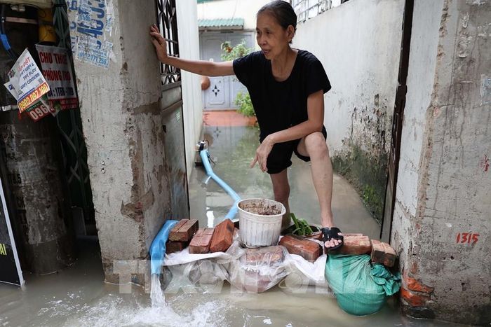 Người dân dùng nhiều biện pháp ngăn nước tràn vào nhà. Ảnh: Vũ Quang – TTXVN