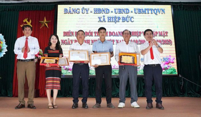 Lãnh đạo xã Hiệp Đức trao tặng giấy khen cho các doanh nghiệp tiêu biểu. Ảnh: TẤN SỸ